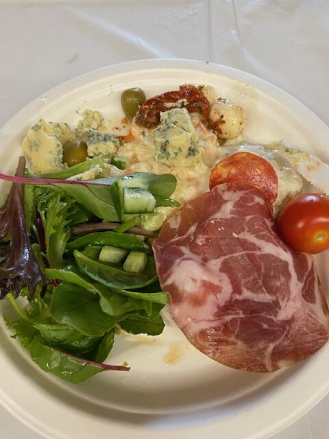 plate of food: salad, coleslaw, tomatoes, jamon