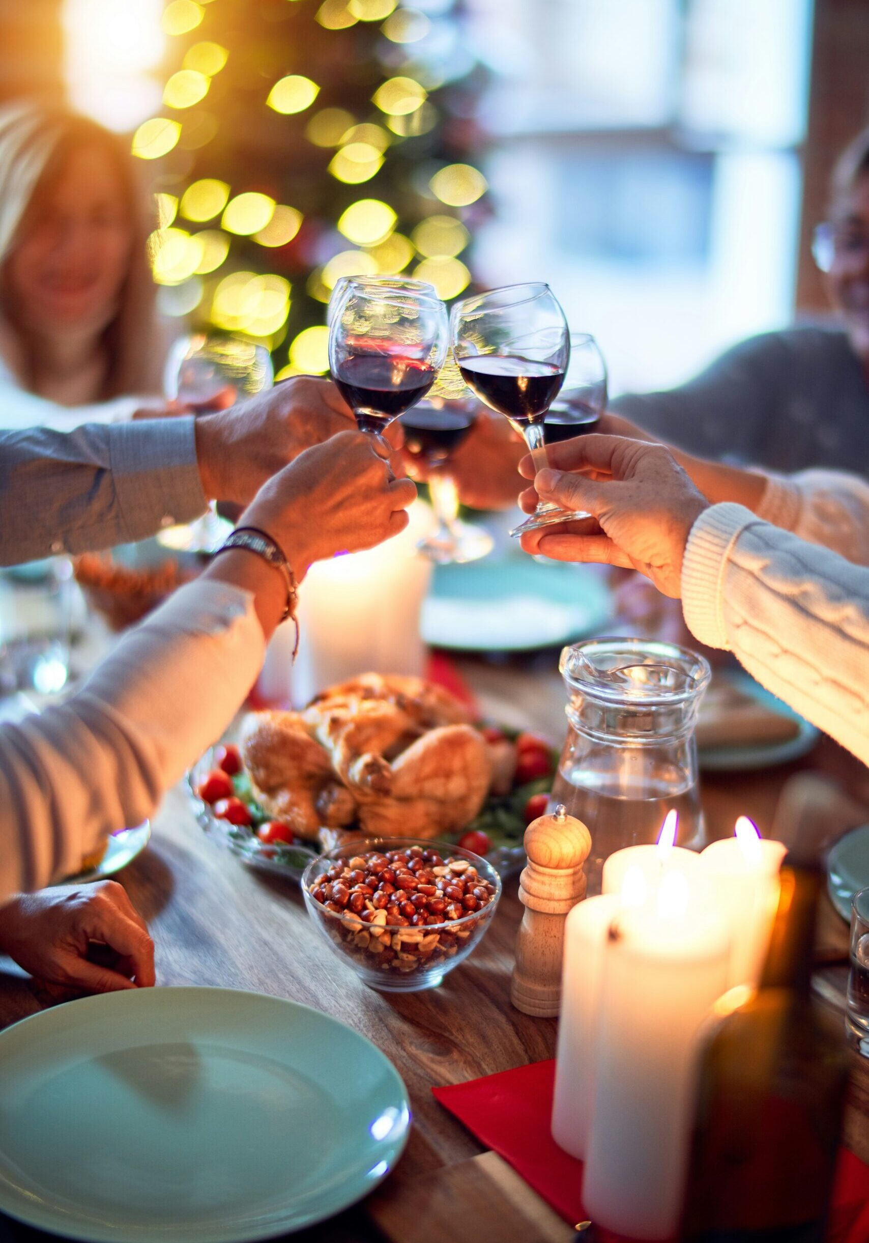 festive dining table with hands holding glasses in a toast