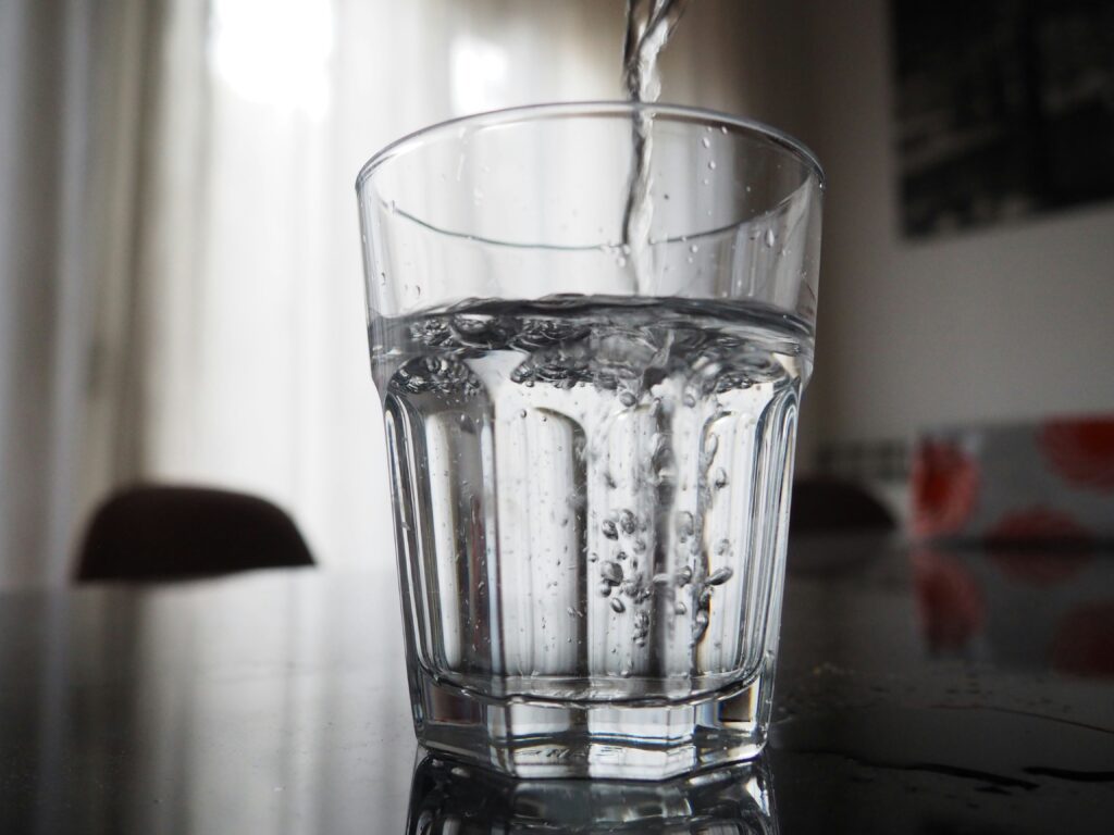 Water pouring into a clear glass tumbler