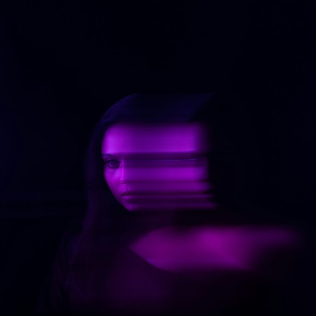 blurry photo of a woman's face tinted in purple