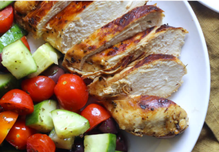 dinner plate with grilled chicken, tomatoes and cucumber