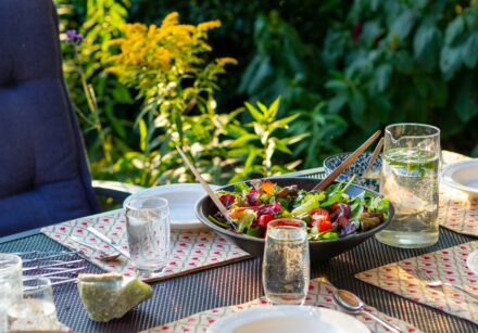 outdoor table set with plates and glasses
